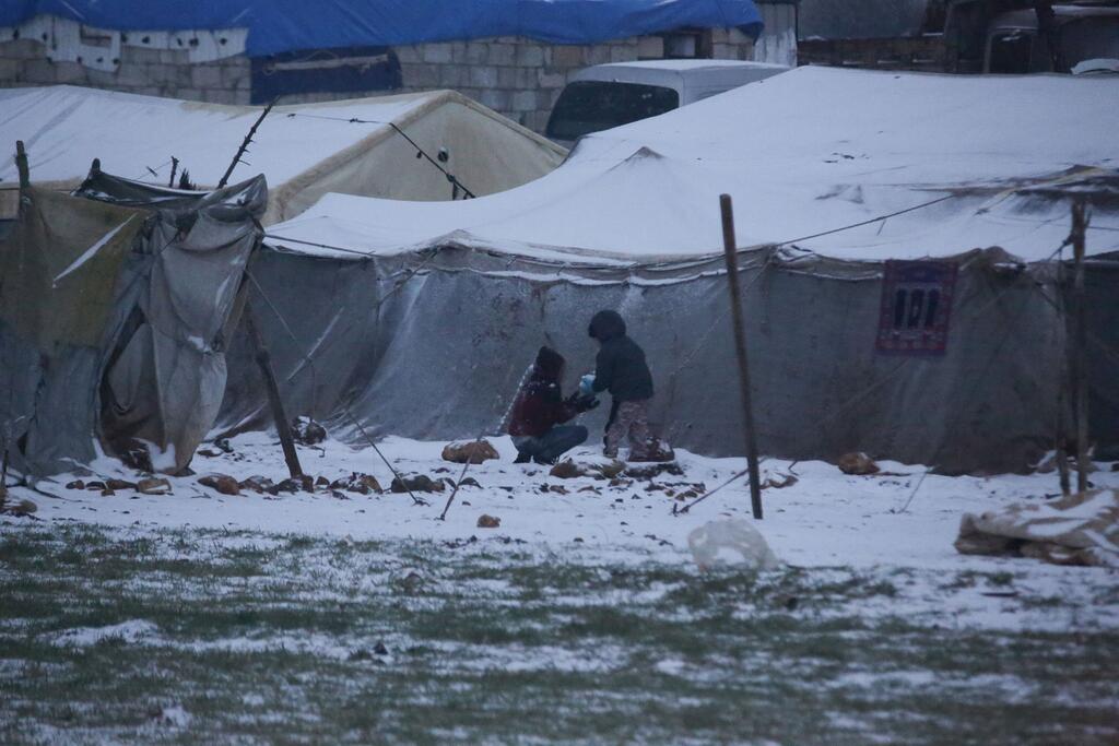 Los niños juegan en la nieve en un asentamiento informal que continúa recibiendo a familias recientemente desplazadas del sur de Idlib y de las provincias rurales de Alepo, en el noroeste de la República Árabe Siria.